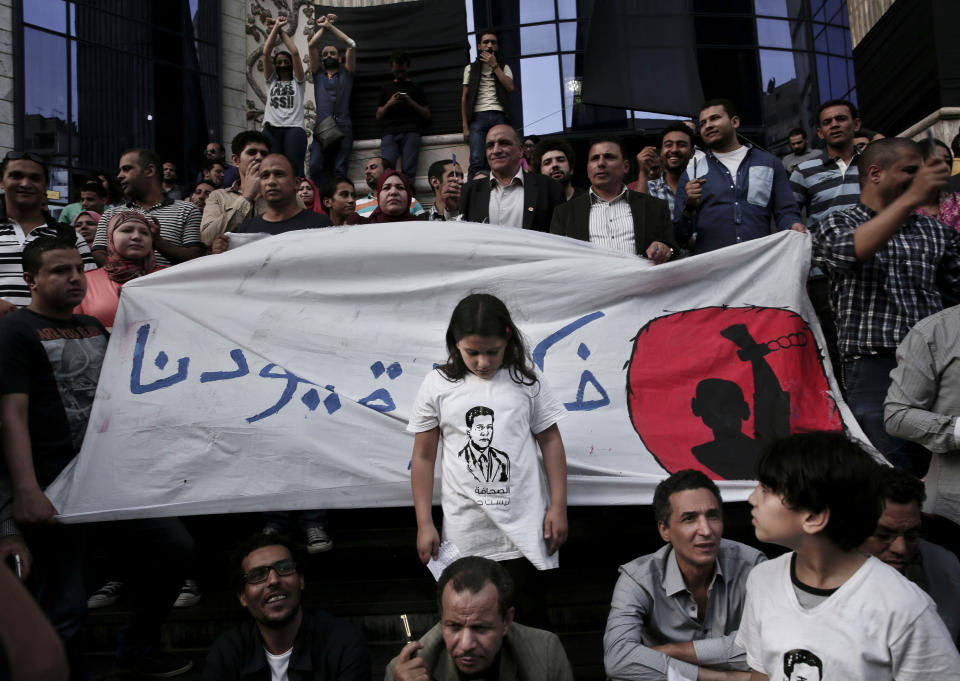 FILE - In this May 3, 2016 file photo, a girl stands in front of a banner with Arabic that reads, "remove our shackles," during a protest to mark World Press Freedom Day in front of the Press Syndicate in Cairo, Egypt. The Supreme Media Regulatory Council has put into effect tighter restrictions that allow the state to block websites and even social media accounts with over 5,000 followers if they're deemed a threat to national security. The media regulator will also be able to impose stiff penalties of 250,000 Egyptian pounds ($14,400), all without having to obtain a court order. (AP Photo/Nariman El-Mofty)