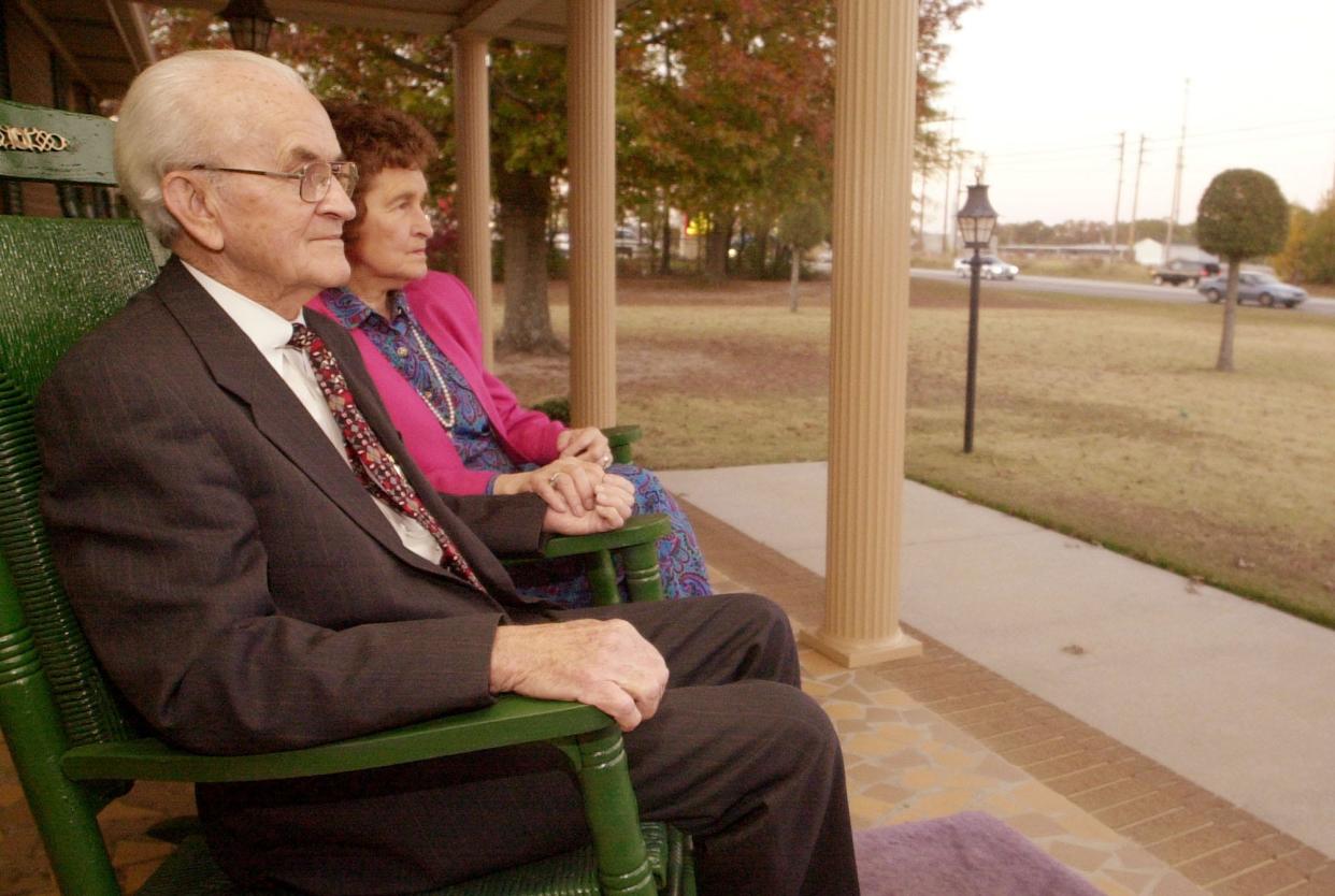 FILE - Swint Bradberry and his wife Elizabeth sit on the front porch of of their home on Whiskey Rd. and watch the traffic on Nov. 8, 2001.