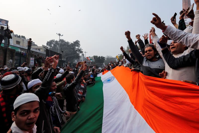 Demonstrators hold the national flag of India as they attend a protest against a new citizenship law, after Friday prayers at Jama Masjid in the old quarters of Delhi