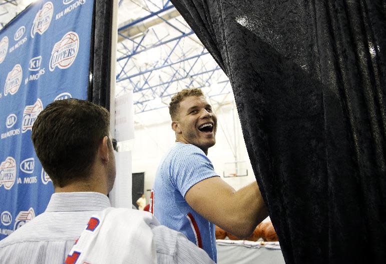 Los Angeles Clippers' Blake Griffin, center, smiles as he walks off the stage after talking to reporters during the team's NBA basketball media day on Monday, Sept. 30, 2013, in Los Angeles. (AP Photo/Jae C. Hong)