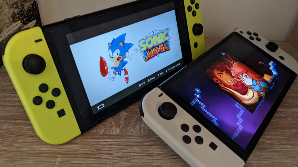 Nintendo Switch OLED showing Celeste and old Switch showing Sonic Mania