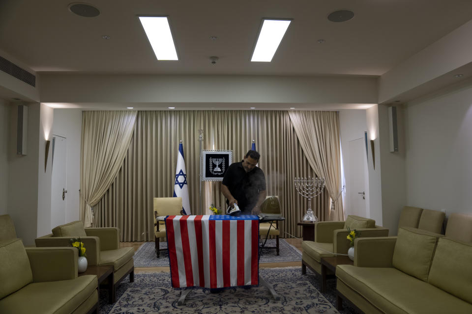 Ronen Sami irons a representation of an American flag ahead of a visit by U.S. President Joe Biden at the Israeli President's residence in Jerusalem, Monday, July 11, 2022. Biden visits Israel and the occupied West Bank this week for the first time since assuming office. (AP Photo/Maya Alleruzzo)