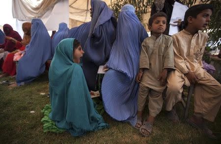 An Afghan refugee girl yawns as she sits with others to have a medical check-up at a health clinic set up by the United Nations High Commissioner for Refugees (UNHCR) to mark World Refugee Day in Islamabad June 20, 2014. REUTERS/Faisal Mahmood