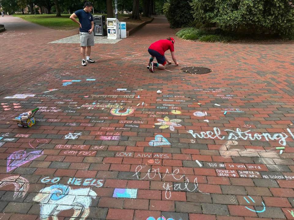 UNC students use chalk to write ‘Heel strong,’ ‘You are loved, ‘Stop gun violence’ and more on the Tuesday following a shooting on campus.