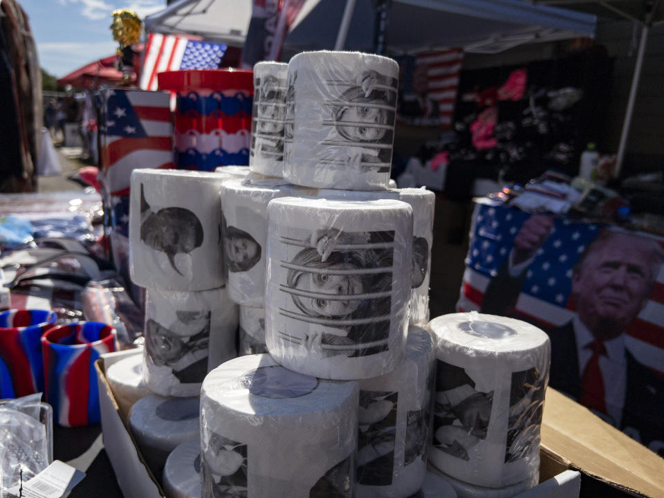 Merchandise, including toilet paper with the image of former Secretary of State Hillary Clinton, is displayed during the ReAwaken America Tour at Cornerstone Church in Batavia, N.Y., Saturday, Aug. 13, 2022. Du Mez, who is writing a book on the overlap of consumerism and Christian identity, says events like this are orchestrated to extract money from participants. They are invited to participate in the movement by pulling out their credit cards. “People give it happily. The skeptical take is this is a scam. That’s not how it feels to the people who are giving their money,” she says. (AP Photo/Carolyn Kaster)