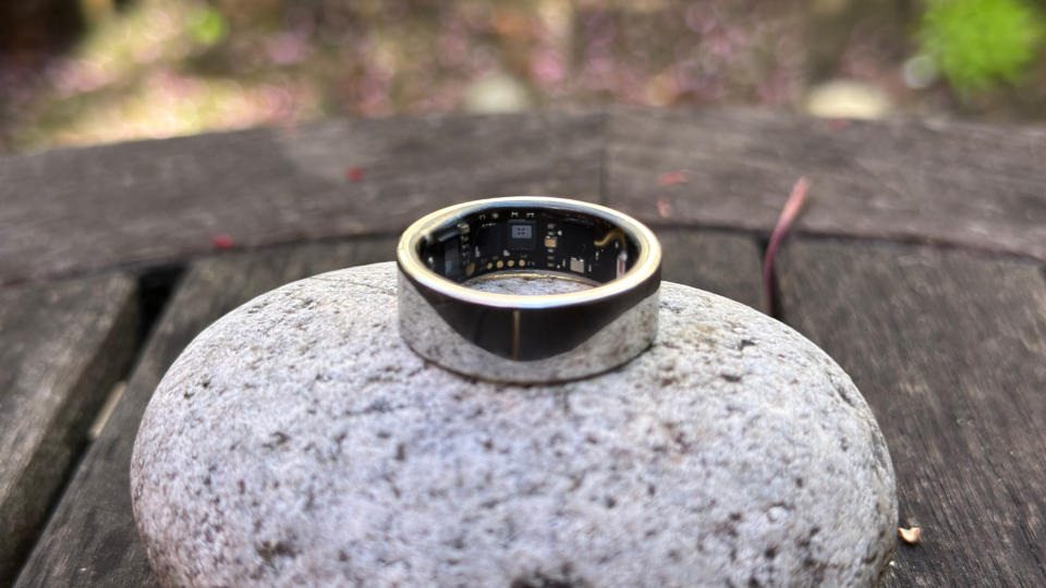 The Ultrahuman Ring Air sitting atop a rock, showing the visible sensors on the inner ring.