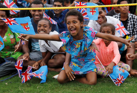 Children smile and wave flags as Britain's Prince Harry and Meghan, Duchess of Sussex, arrive in Suva, Fiji, October 23, 2018. REUTERS/Phil Noble