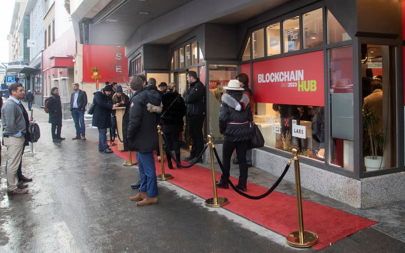 People stand in front of the Blockchain Hub Davos 2023 during the World Economic Forum in Davos