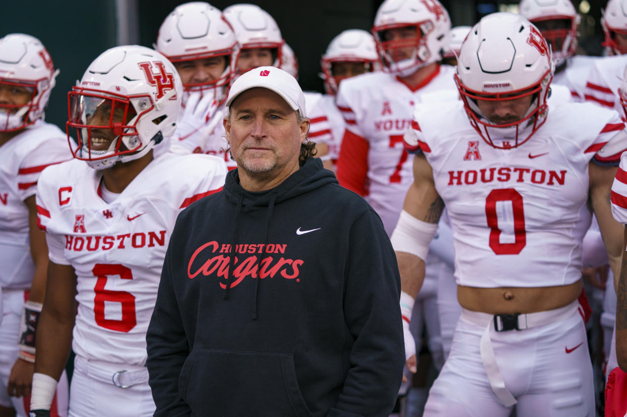 Houston head coach Dana Holgorsen, center, waits to lead his team onto the field before an NCAA college football against Temple, Saturday, Nov. 13, 2021, in Philadelphia. (AP Photo/Chris Szagola)