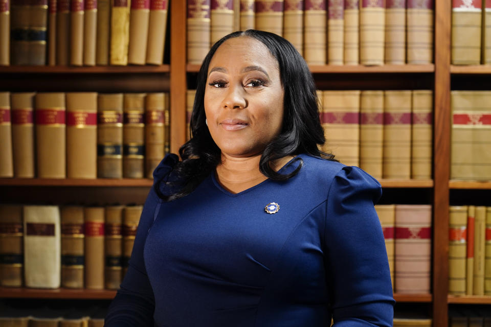 Fulton County District Attorney Fani Willis poses for a portrait in front of filled bookshelves.