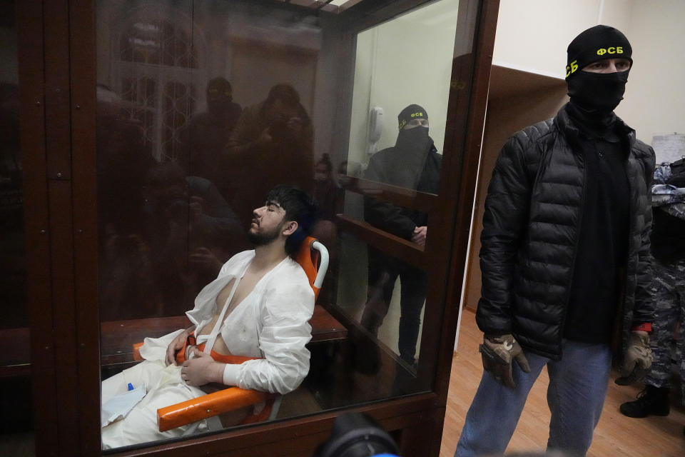 Mukhammadsobir Faizov, a suspect in Friday's shooting at the Crocus City Hall, sits in a glass cage in the Basmanny District Court in Moscow, Russia, Sunday, March 24, 2024. The four men charged with the massacre at a Moscow theater have been identified by the Russian government as citizens of Tajikistan, some of the thousands who migrate each year from the poorest of the former Soviet republics to scrape out marginal existences. (AP Photo/Alexander Zemlianichenko)