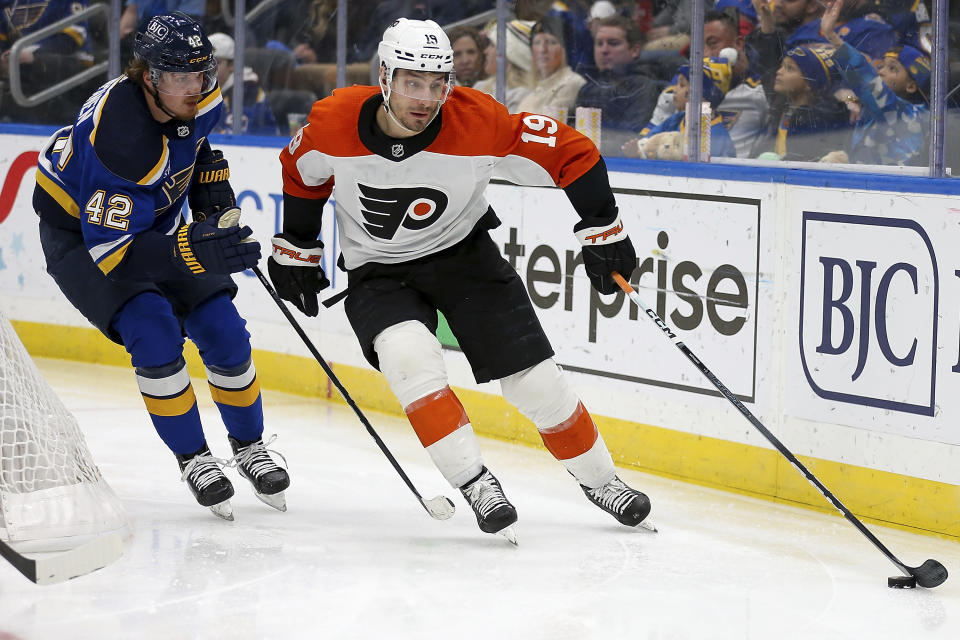 Philadelphia Flyers' Garnet Hathaway (19) controls the puck under pressure from St. Louis Blues' Kasperi Kapanen (42) during the third period of an NHL hockey game Monday, Jan. 15, 2024, in St. Louis. (AP Photo/Scott Kane)