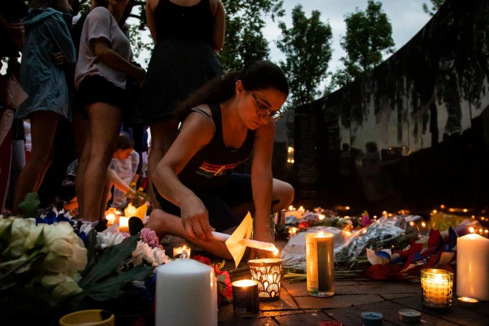 Dozens of mourners gather for a vigil near Central Avenue and St Johns Avenue in downtown Highland Park (AP)