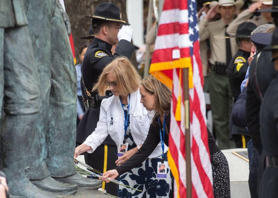 Jessica Lenehan, right, places a rose Monday for her husband Tyler Lenehan, a member of the Elk Grove Police Department killed by a wrong-way driver last year, on the California Peace Officers’ Memorial during the ceremony at the state Capitol.