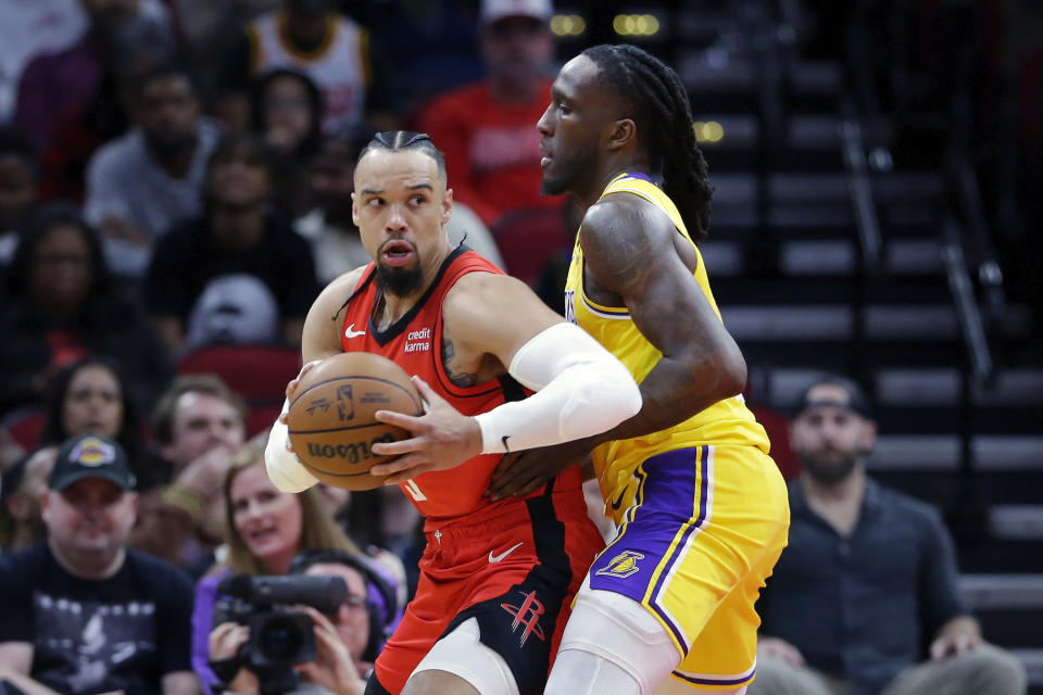 Houston Rockets forward Dillon Brooks, left, spins to the basket in front of Los Angeles Lakers forward Taurean Prince, right, during the first half of an NBA basketball game Monday, Jan. 29, 2024, in Houston. (AP Photo/Michael Wyke)