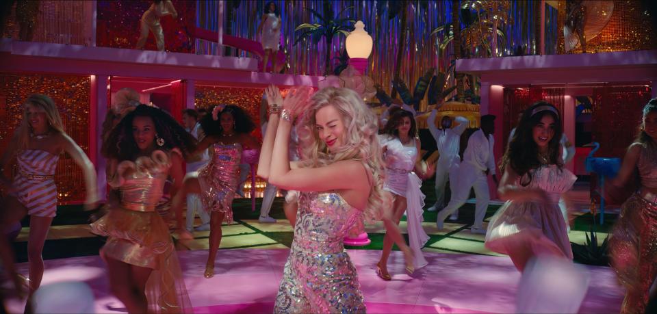 Margot Robbie dancing around a group of people