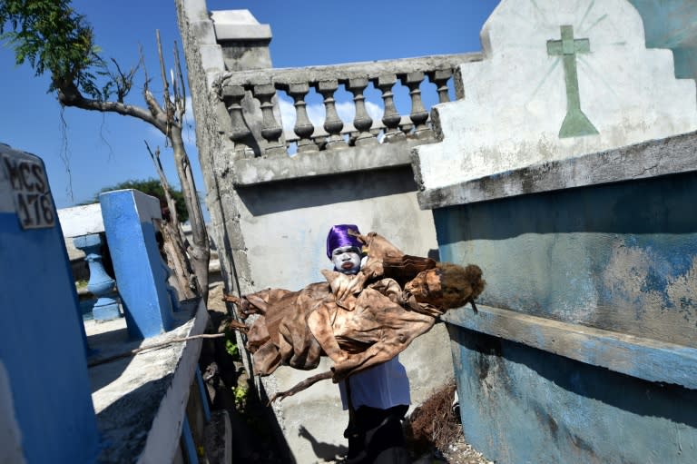 A voodoo devotee in a trance takes a body from a grave in a cemetery in Port-au-Prince, Haiti