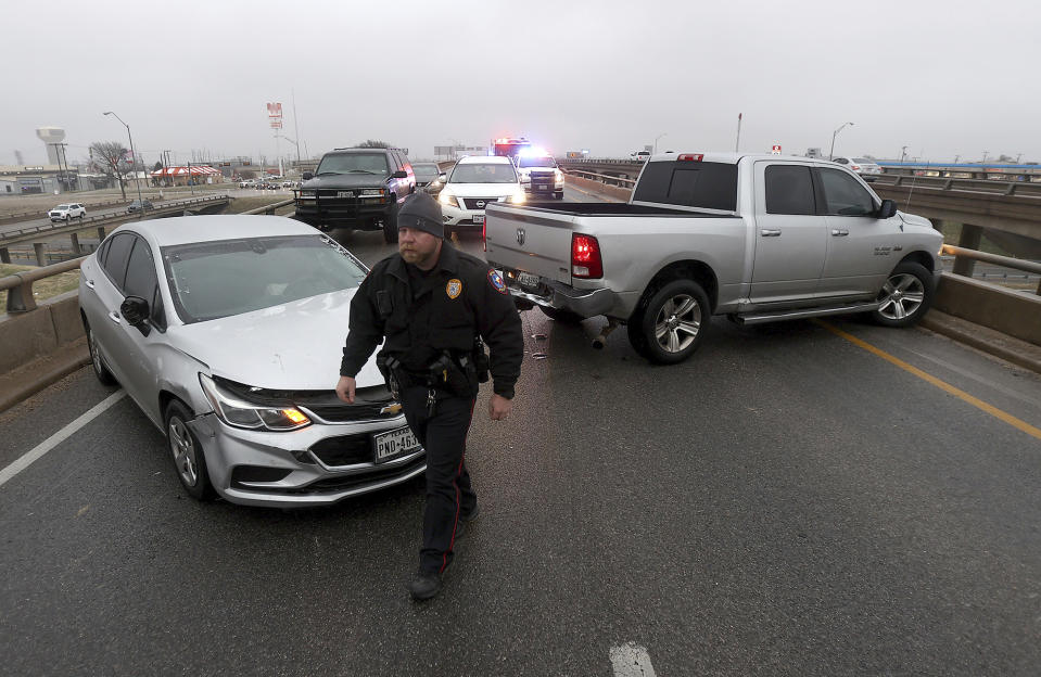 A Waco police officer works the scene of a four vehicle accident on Highway 6 on Tuesday Jan. 31, 2023, in Waco, Texas. Winter weather brought ice to Texas and nearby states Tuesday. (Jerry Larson/Waco Tribune-Herald via AP)