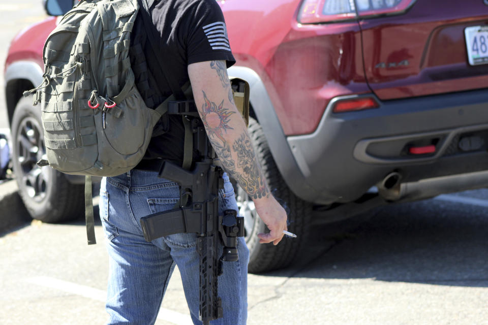 A right-wing protester carries a weapon outside the Oregon State Capitol in Salem, Ore., on Monday, Sept. 7, 2020. Hundreds of people gathered on Labor Day in a small town south of Portland for a pro-President Donald Trump vehicle rally, just over a week after member of a far-right group was fatally shot after a Trump caravan went through Oregon's largest city. Later, pro-Trump supporters and counter-protesters clashed at Oregon's Capitol. (AP Photo/Andrew Selsky)