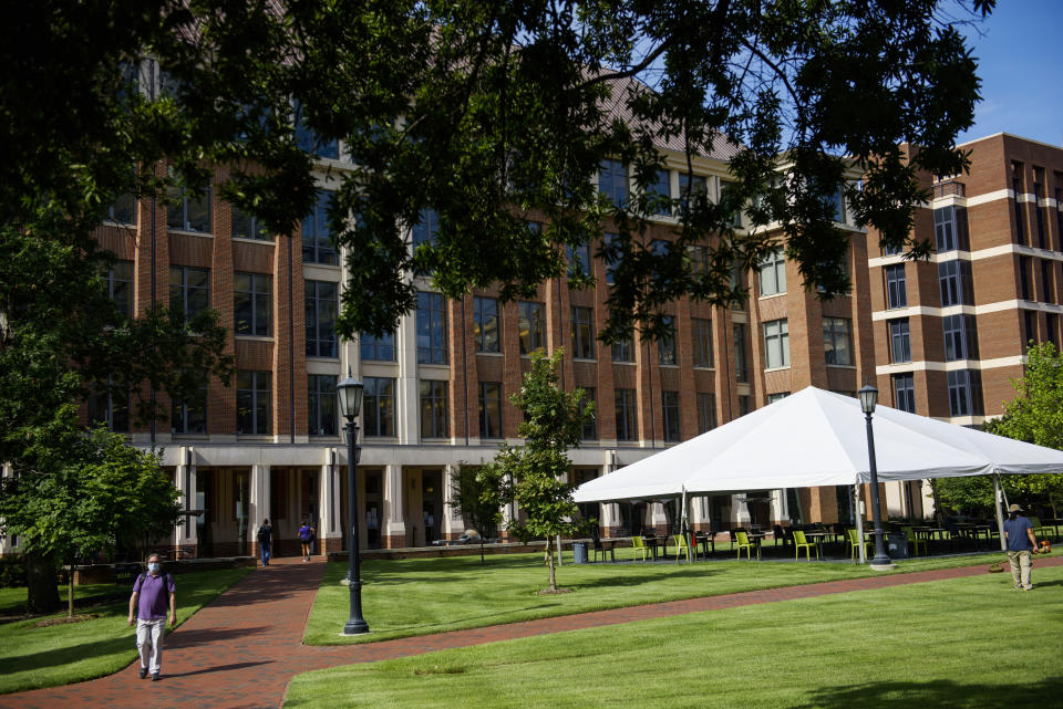 CHAPEL HILL, NC - AUGUST 18: Students and faculty walk through an open area outside the School of Medicine on the campus of the University of North Carolina at Chapel Hill on August 18, 2020 in Chapel Hill, North Carolina. The school halted in-person classes and reverted back to online courses after a rise in the number of COVID-19 cases over the past week. (Photo by Melissa Sue Gerrits/Getty Images)