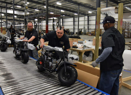 Jamison Spurlock (C) pushes a mini-bike forward on an assembly line at motorcycle and go-kart maker Monster Moto in Ruston, Louisiana January 25, 2017. Picture taken January 25, 2017. REUTERS/Nick Carey