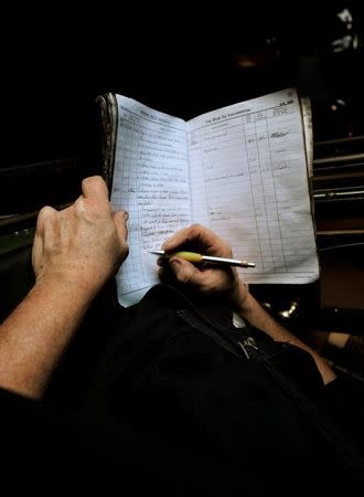 Puffing Billy steam engine driver Steve Holmes, 61, makes notes on the performance and problems of locomotive 6A in a daily log book following a day's work at Belgrave near Melbourne, October 17, 2014. REUTERS/Jason Reed