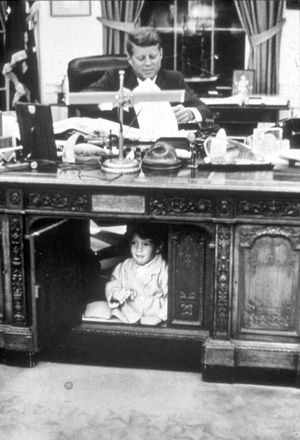 <p>John F. Kennedy Jr. plays under the Resolute Desk.</p>