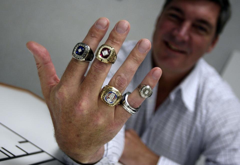 Detroit Shock head coach Bill Laimbeer holds up his championship rings (from left) 2003 Shock, 1990 Pistons, 1989 Pistons, 2003 ladies Shock and 2006 prototype Shock ring at the Palace of Auburn Hills, March 28, 2007.