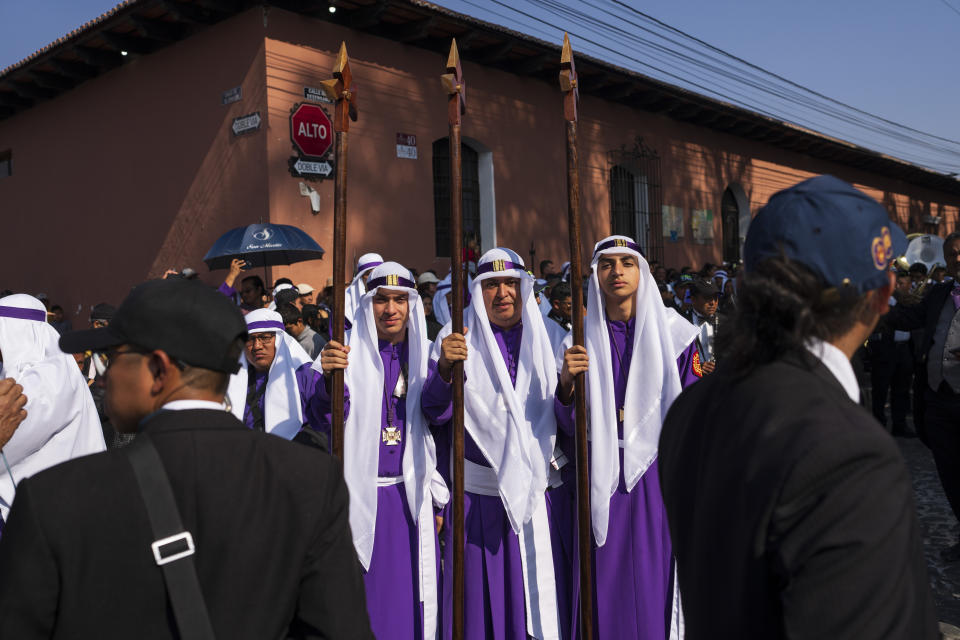 Francisco González-Figueroa, centro, y sus hijos Santiago, derecha, y Sebastian, posan para la foto durante la procesión de Semana Santa en Antigua, Guatemala, el Viernes Santo, 29 de marzo de 2024. (AP Foto/Moisés Castillo)