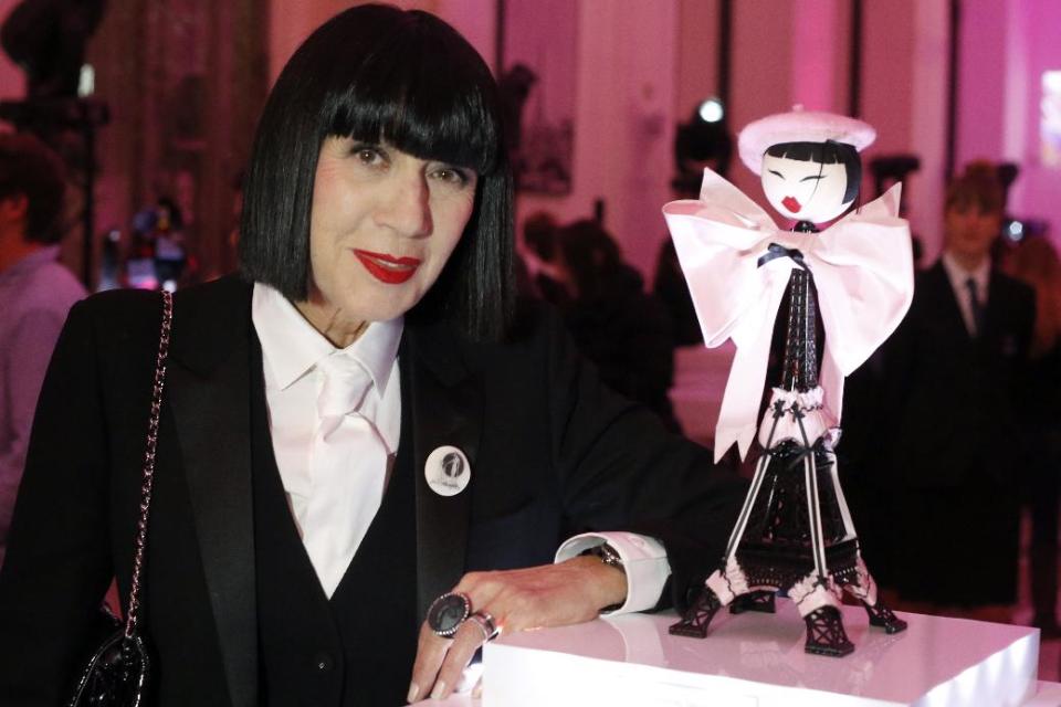 French designer Chantal Thomass poses next to her creation as part of Frimousses puppets collection displayed at the Petit Palais, in Paris, Monday Nov. 25, 2013. The world's top fashion houses from Chanel, Prada and Christian Dior have brought together their needlework in a unique charitable venture: each designing children's dolls that will be sold at auction for UNICEF. (AP Photo/Francois Mori)