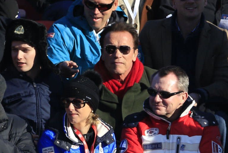 US-American actor Arnold Schwarzenegger (C) and his son (L) attend the FIS World Cup men's downhill race on January 26, 2013 in Kitzbuehel, Austrian Alps