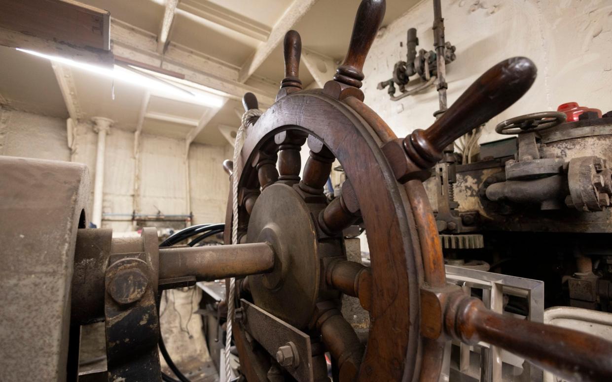 The ship's wooden helm is seen in close-up