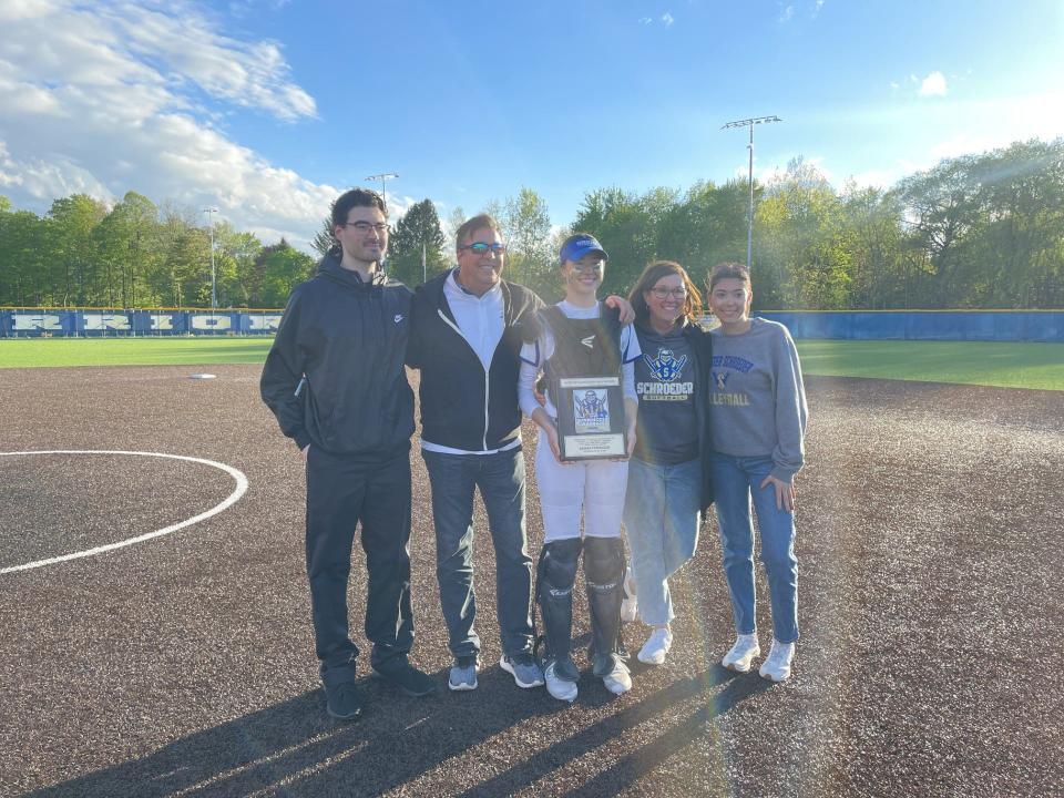 Webster Schroeder senior Sarah Ferruzza shares a moment with her family after being honored as the Warriors' all-time winningest athlete Wednesday, May 8, 2024.