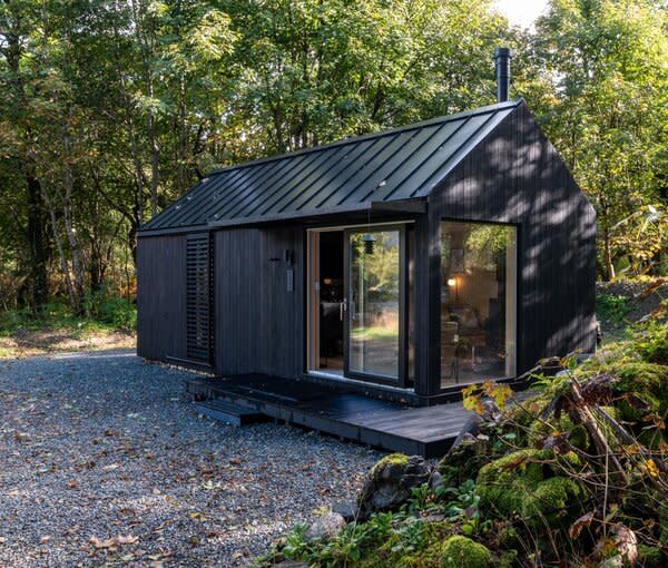 Kabn 2 was designed so that its long side faces the loch. Apart from providing entry into the home, the glazed corner of cabin frames the water just past a gravel path.