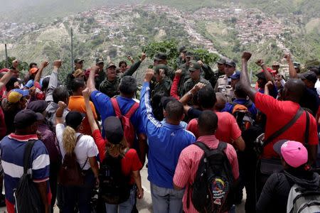 Venezuelan army officers and soldiers talk with people of San Pedro slum as part of military drills in Caracas, Venezuela, May 20, 2016. REUTERS/Marco Bello