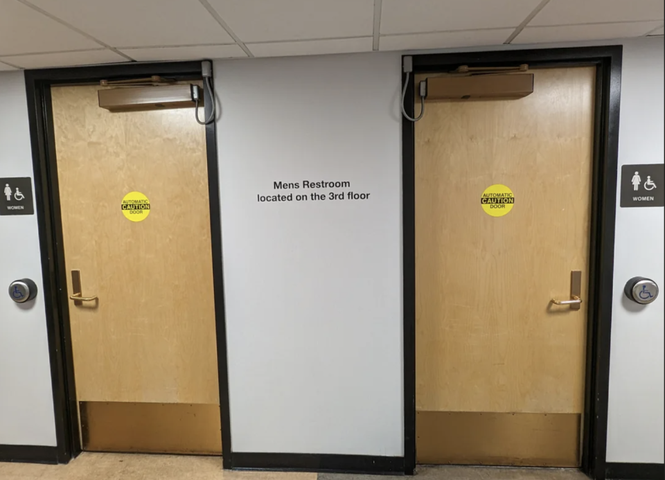 Two restroom doors with signs indicating the men's restroom is on the 3rd floor