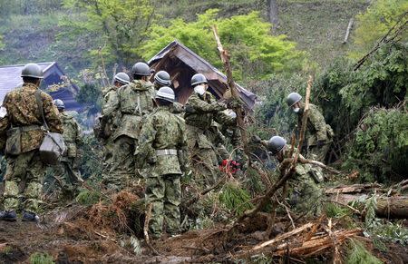 Japan Ground Self-Defense Force soldiers conduct search and rescue operations for a missing guest at a destroyed mountain villa following a landslide site caused by an earthquake in Minamiaso town, Kumamoto prefecture, southern Japan, in this photo taken by Kyodo April 18, 2016. Mandatory credit REUTERS/Kyodo