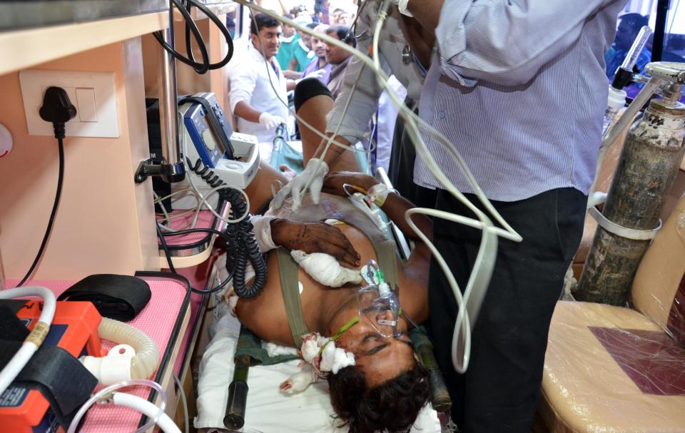 Medics attend to a paramilitary soldier injured in an ambush in Chhattisgarh state, at a hospital in Raipur, India, Tuesday, March 11, 2014. Maoist rebels ambushed paramilitary soldiers in a brazen daytime attack on their camp in central India on Tuesday, killing 20 troops in their largest attack in almost a year, police said. (AP Photo/Rupesh Yadav)