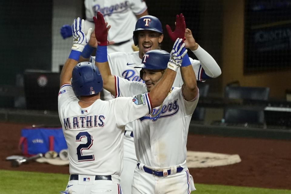 Texas Rangers' Jeff Mathis (2), Anderson Tejeda, right, and Ronald Guzman, rear, celebrate Mathis' three-run home run that scored them in the seventh inning of a baseball game against the Houston Astros in Arlington, Texas, Saturday, Sept. 26, 2020. (AP Photo/Tony Gutierrez)