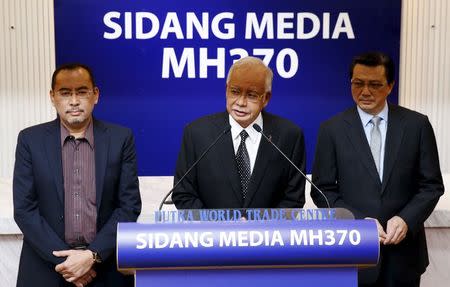 Malaysia's Prime Minister Najib Razak (C) with Minister for Transport Liow Tiong Lai (R) confirms the debris found on Reunion Island is from missing Malaysia Airlines flight MH370 in Kuala Lumpur, Malaysia, August 6, 2015. REUTERS/Olivia Harris