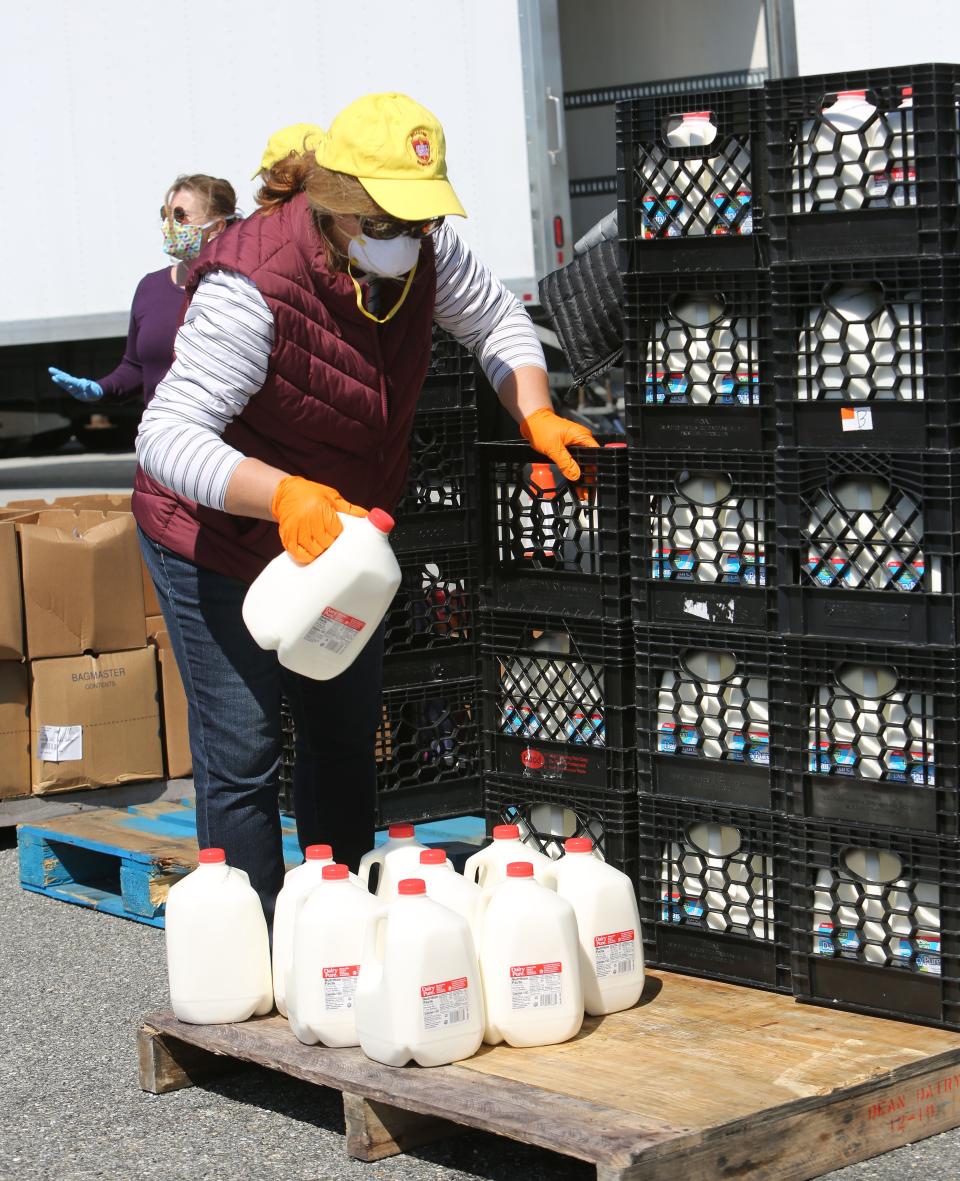 Lynn Cosden prepares cartons of milk for drivers who came to the Food Bank of Delaware's food giveaway event in April 2020 at the Dover International Speedway.