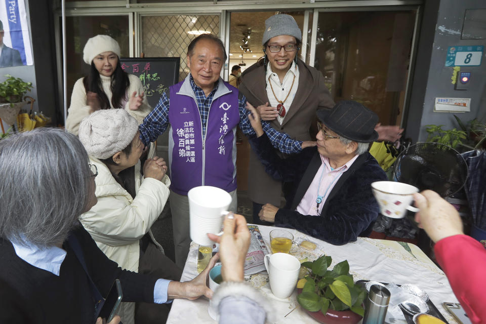 Chui Pak-tai, center, a Taiwanese of Hong Kong descent, cheers with supporters during an interview with The Associated Press at his campaign headquarters in New Taipei City, Taiwan, on Dec. 4, 2023. At 72, Chui, a former Hong Kong pro-democracy district councilor who secured Taiwan residency 11 years ago, is running for legislative office. Although he faces long odds, his campaign draws attention to the immigration challenges of the Hong Kong diaspora.(AP Photo/Chiang Ying-ying)