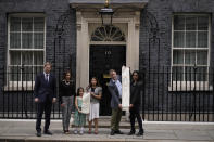 Imprisoned British-Iranian woman Nazanin Zaghari-Ratcliffe's husband Richard Ratcliffe, second right, and their seven year old daughter Gabriella pose for the media with, from left, Conservative Party MP Tobias Ellwood, Elika Ashoori whose British-Iranian father Anoosheh Ashoori is detained in Iran, and Labour Party MPs Tulip Siddiq and Janet Daby holding a petition outside 10 Downing Street, London, on the day marking 2,000 days since Nazanin Zaghari-Ratcliffe has been detained in Iran, Thursday, Sept. 23, 2021. Zaghari-Ratcliffe was originally sentenced to five years in prison after being convicted of plotting the overthrow of Iran's government, a charge that she, her supporters and rights groups deny. While employed at the Thomson Reuters Foundation, the charitable arm of the news agency, she was taken into custody at the Tehran airport in April 2016 as she was returning home to Britain after visiting family. (AP Photo/Matt Dunham)