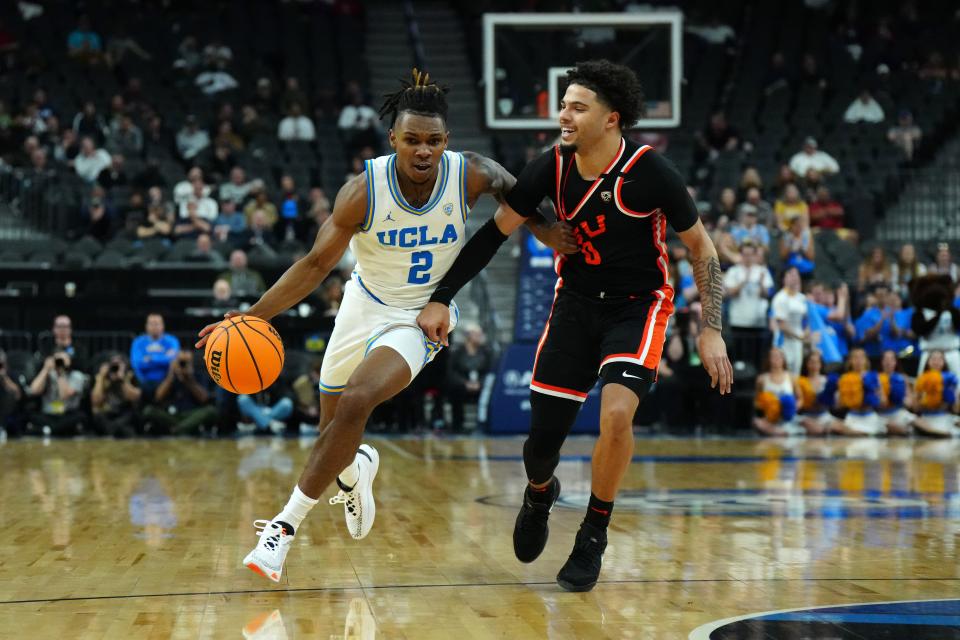UCLA Bruins guard Dylan Andrews (2) dribbles the ball against Oregon State Beavers Jordan Pope (0) in the first half at T-Mobile Arena Wednesday, March 13, 2024, in Las Vegas.