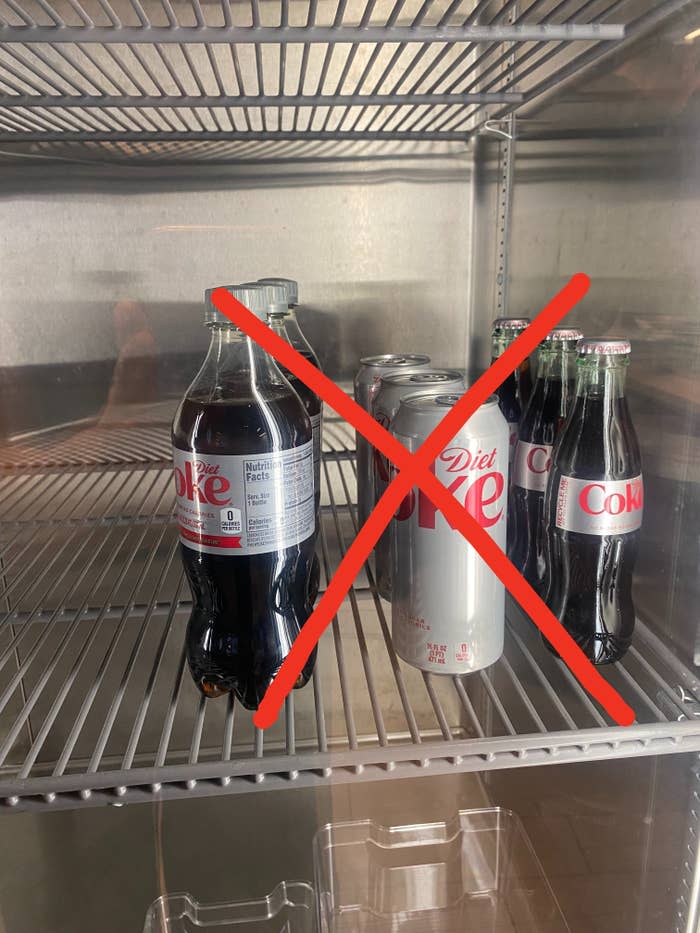 Bottles and cans of Diet Coke in a fridge with an "x" through them