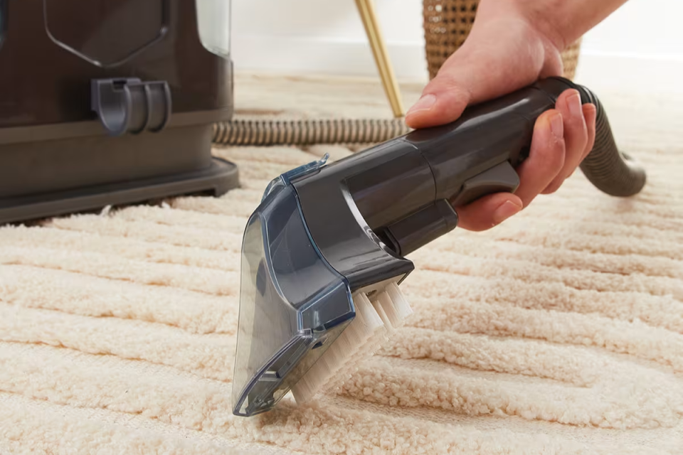 Kmart spot cleaner cleaning a rug.