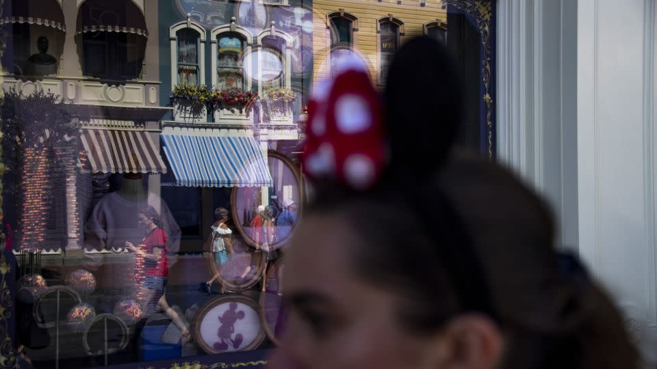 A woman wearing Minnie Mouse ears walks down Main Street USA at the Magic Kingdom Park at Walt Disney World in Orange County, Florida on June 1, 2022. - Joseph Prezioso/Anadolu Agency/Getty Images