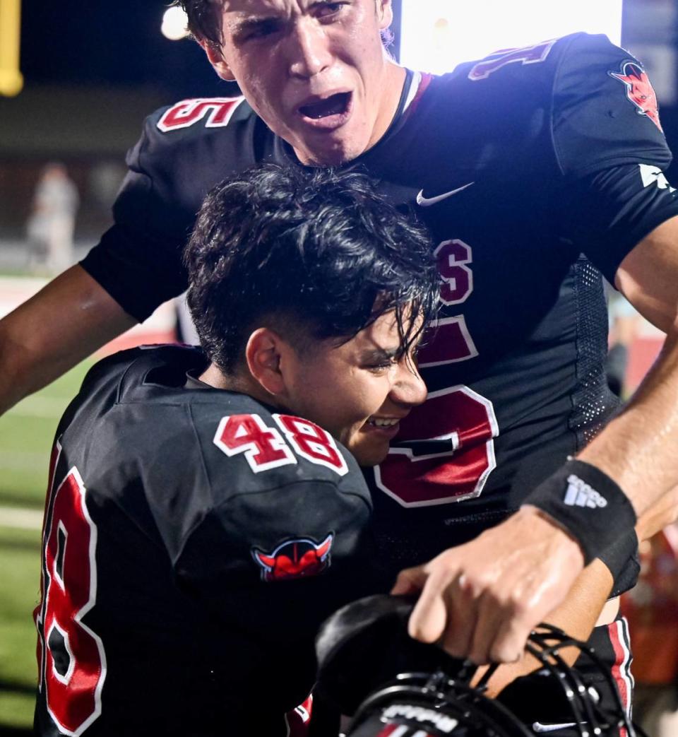 Warner Robins kicker Alberto Medina (48) gets a hug from quarterback Judd Anderson (15) after his game wnning field goal to defeat Ware County 23-21 Friday night.