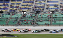 Drivers head out of Turn 4 along the sparsely filled grandstands during an Xfinity Series auto race at Kansas Speedway in Kansas City, Kan., Saturday, Oct. 23, 2021. (AP Photo/Colin E. Braley)