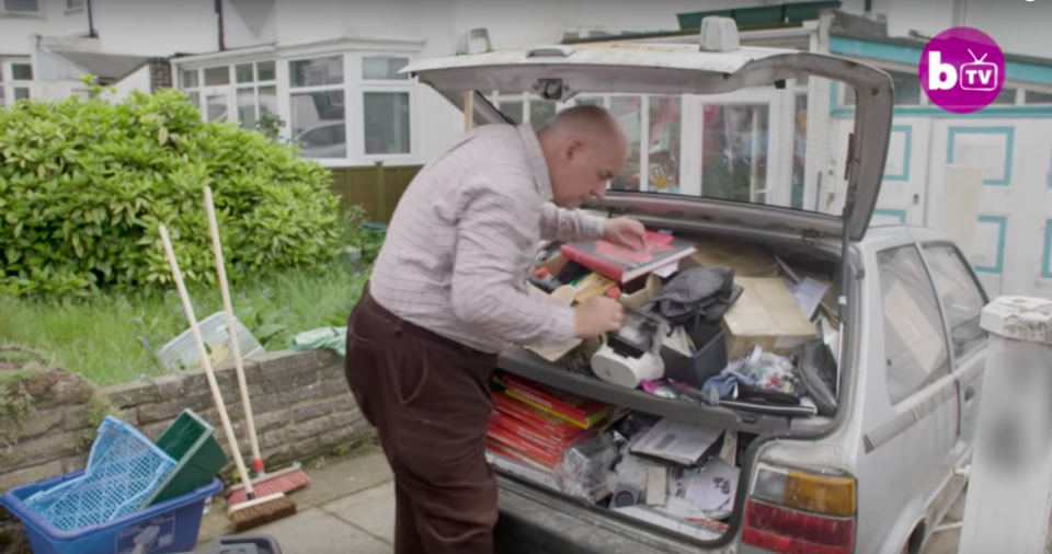 Michael, attempting to clear some of the clutter from his car. Source: Barcroft